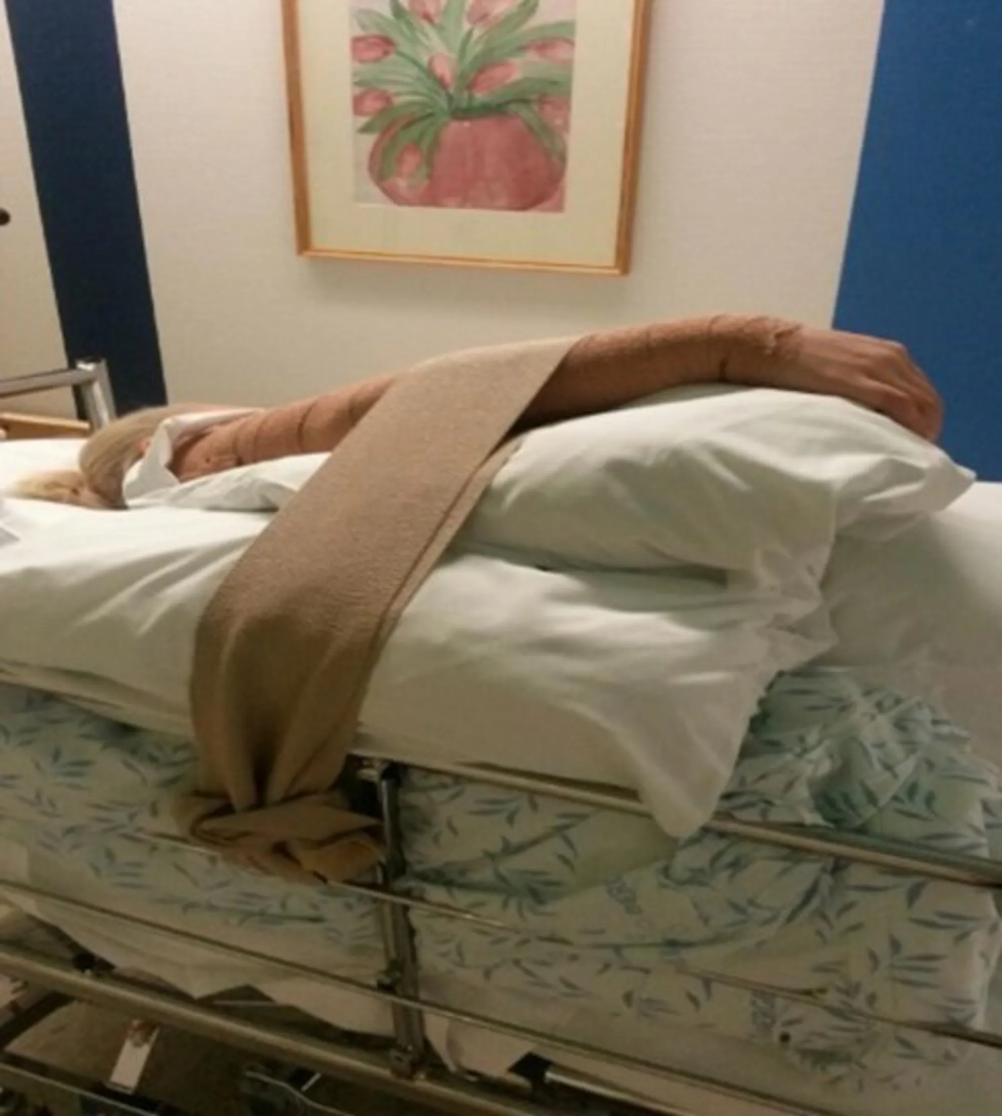 En person som ligger på en seng med sikring av armen