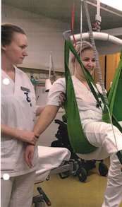 En person i en personløfter med grønt seil