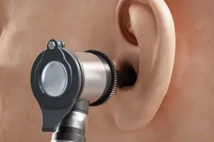 Et nærbilde av et øre og et otoskop, som blir brukt i hørselstest.