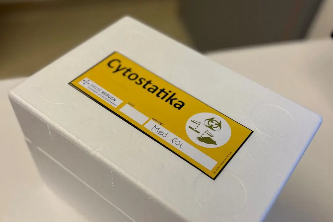 En hvit boks cystostatika med gul merkelapp på.