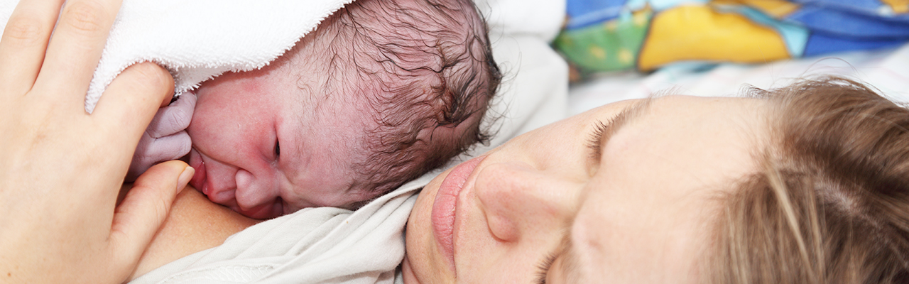 Nyfødt baby hviler på mors bryst. Foto.