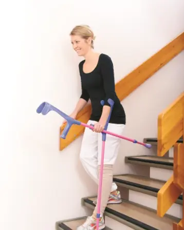 Dame går ned en trapp med krykker