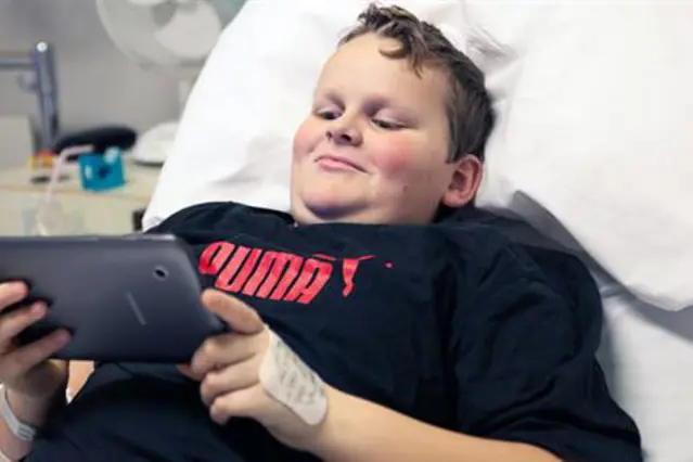 En gutt som ligger i en sykehusseng