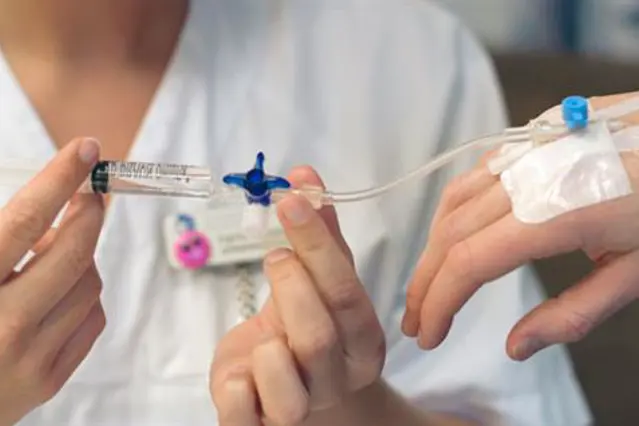 En lege som holder et stetoskop over en persons hånd