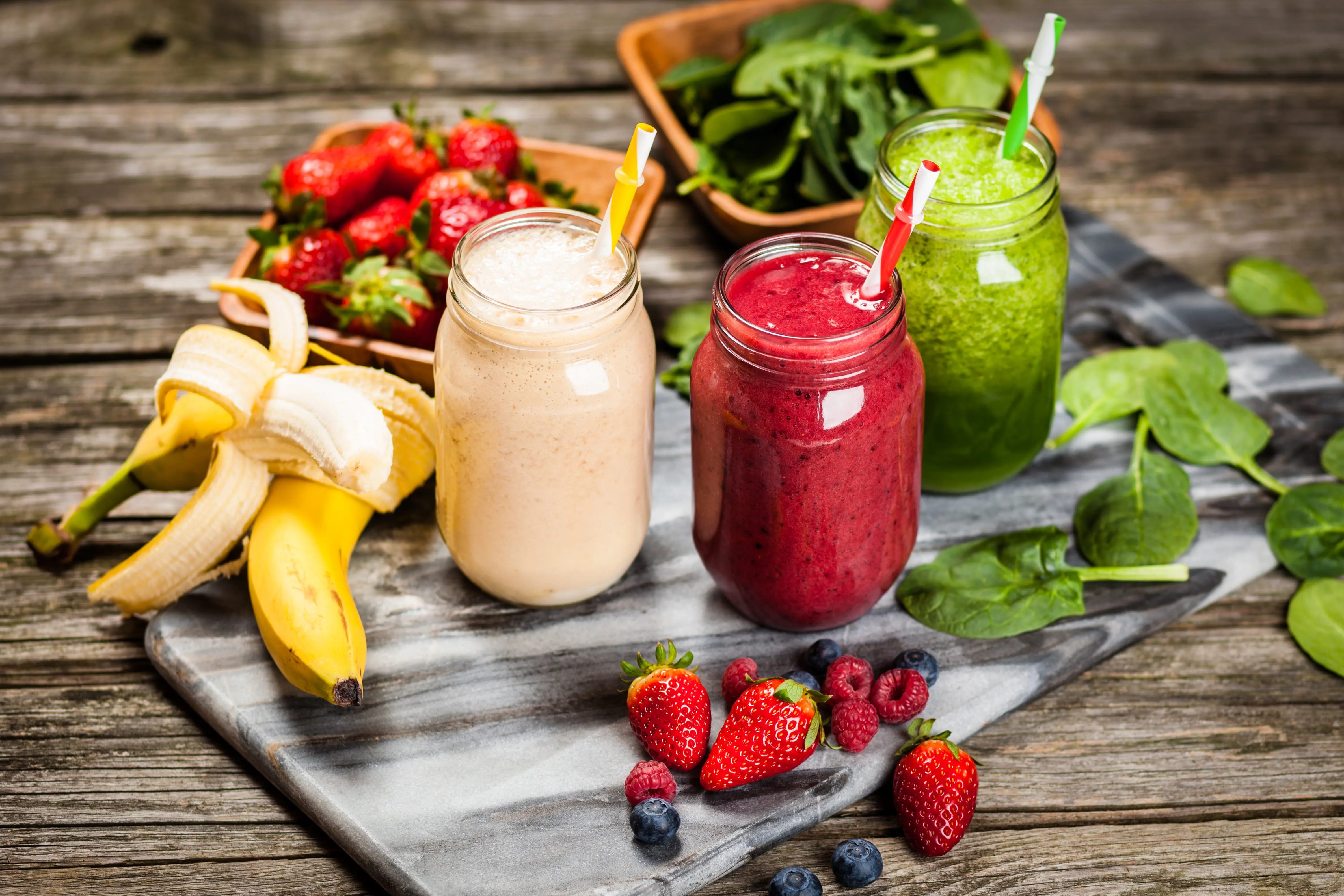 Bilde av masse forskjellig frukt og tre glass med smoothies