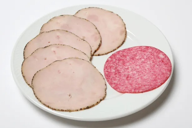 En tallerken med en dansk salamiskive og fem skiver skinke.