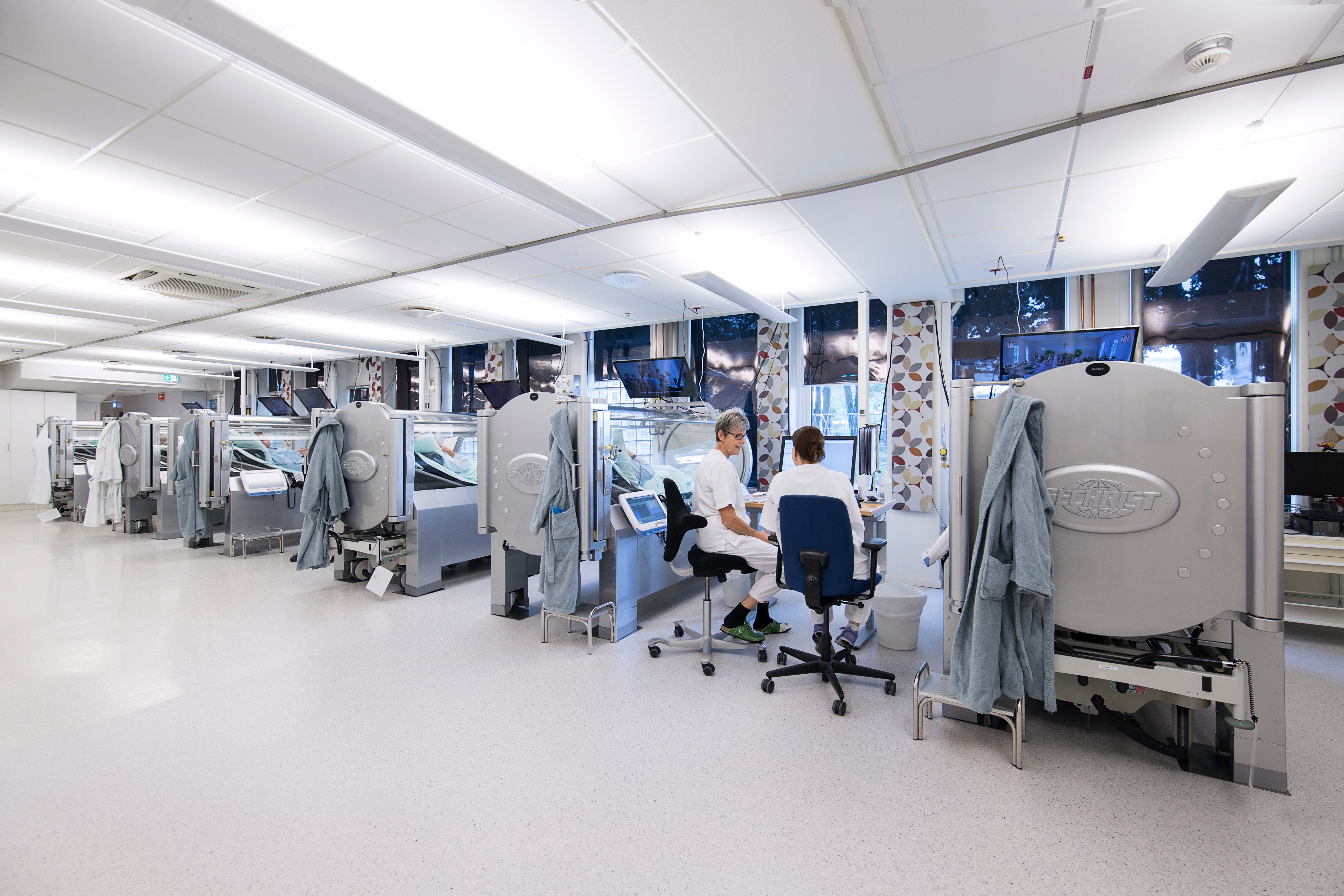 Sykepleiere overvåker pasienter i trykkammer som får hyperbar oksygenbehandling. Foto