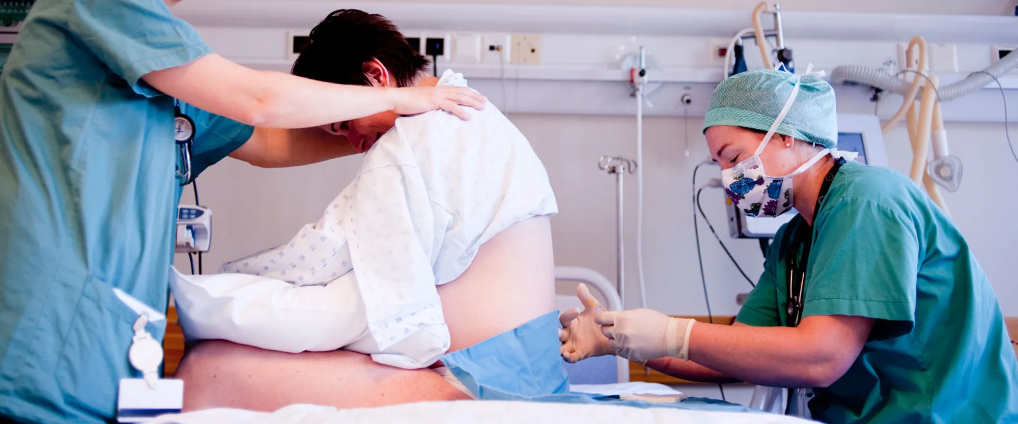 Anestesilege set epiduralbedøving på kvinne som føder