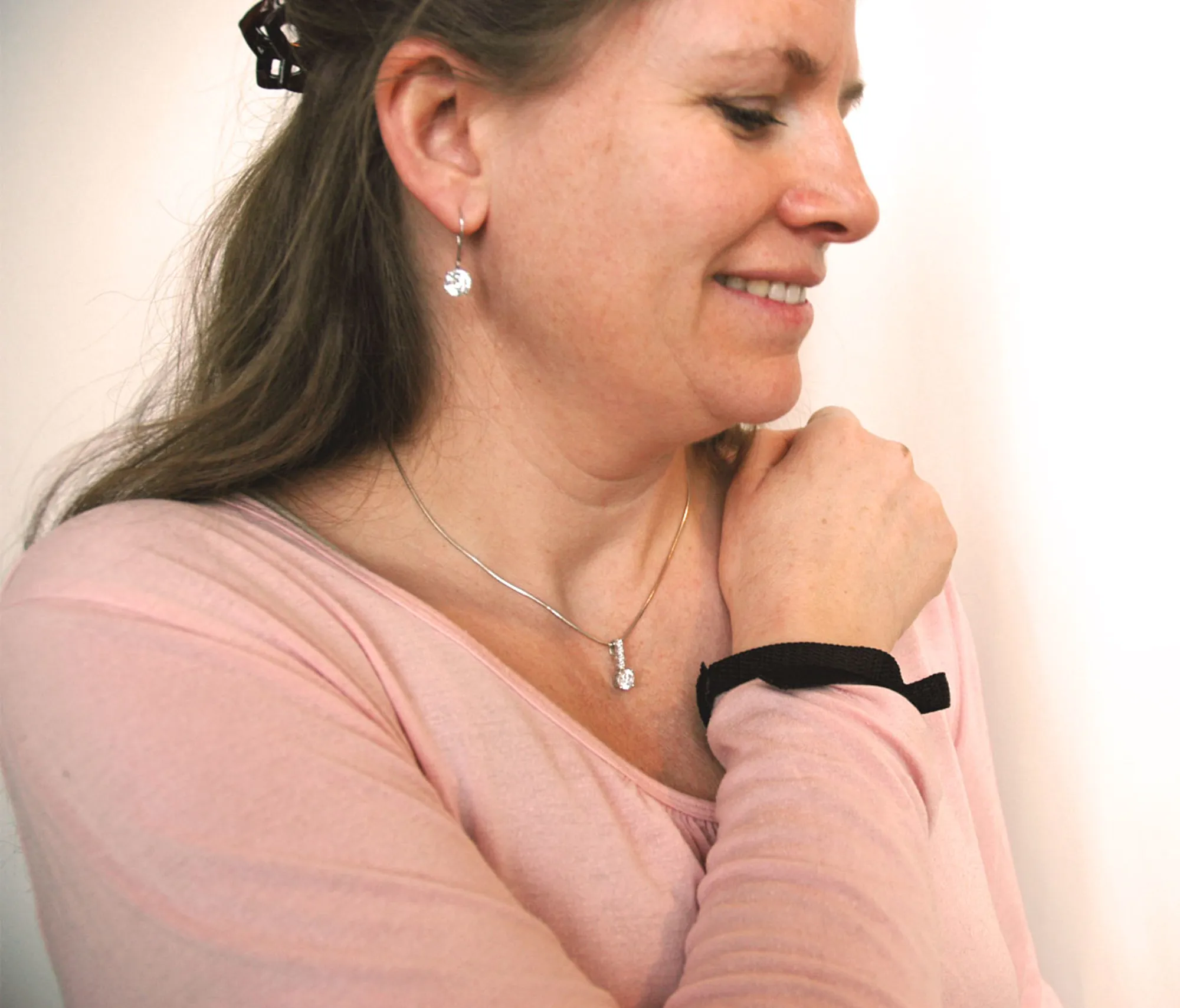Pasient bruker magnetarmbånd til å regulere stimulator. Bilde
