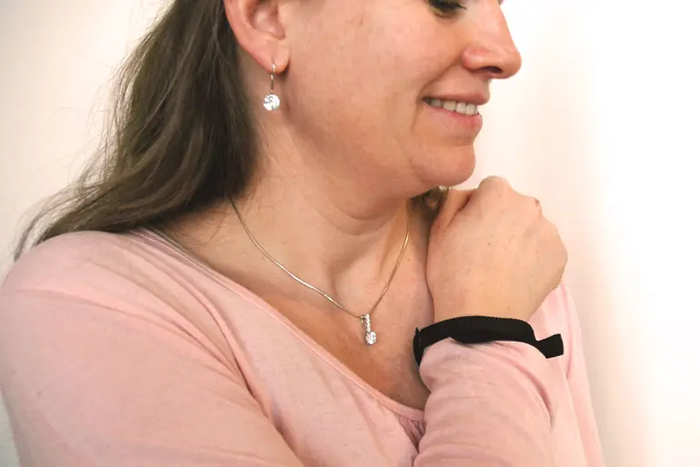 Pasient bruker magnetarmbånd til å regulere stimulator. Bilde