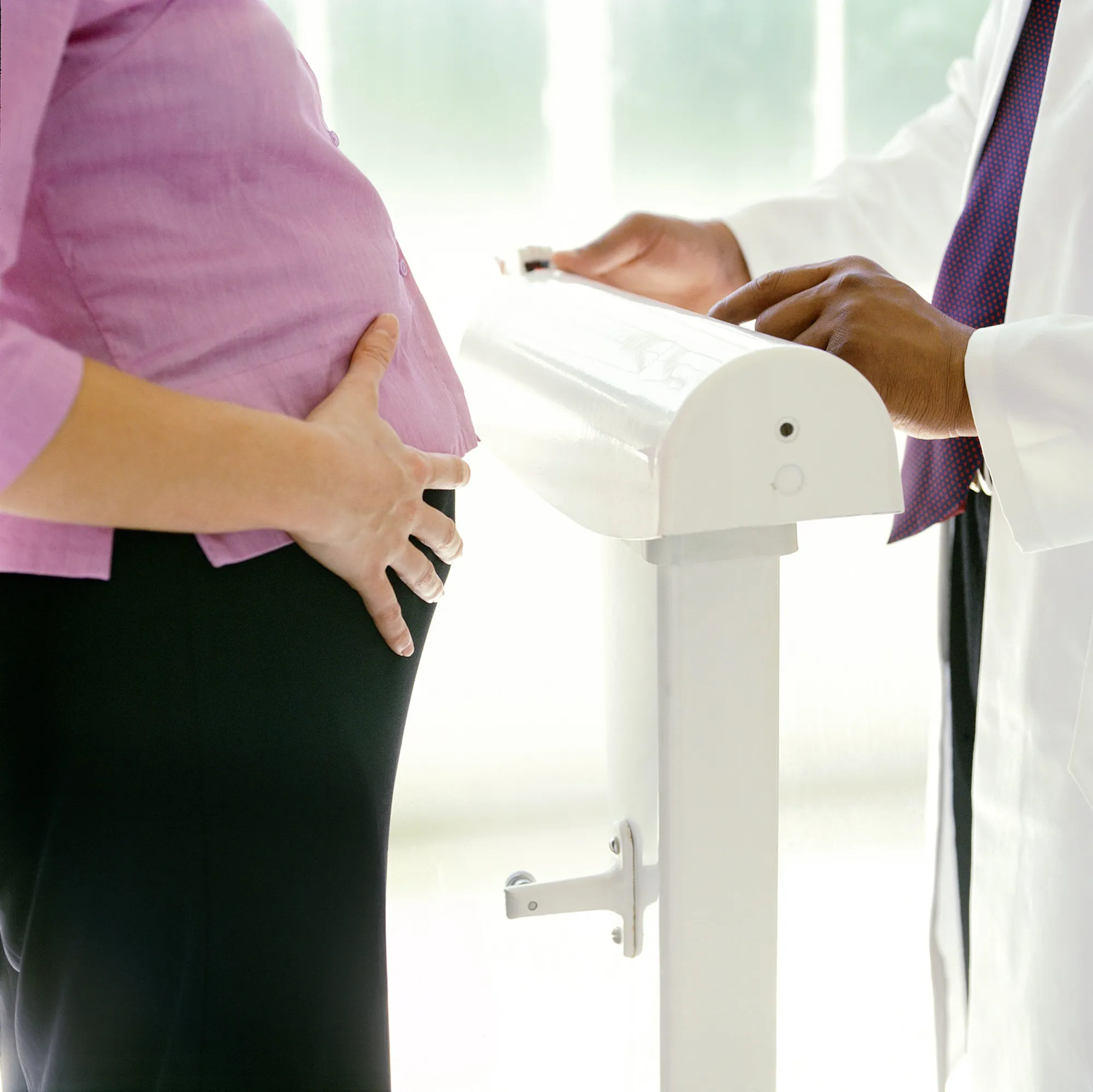 Gravid kvinne står på vekt