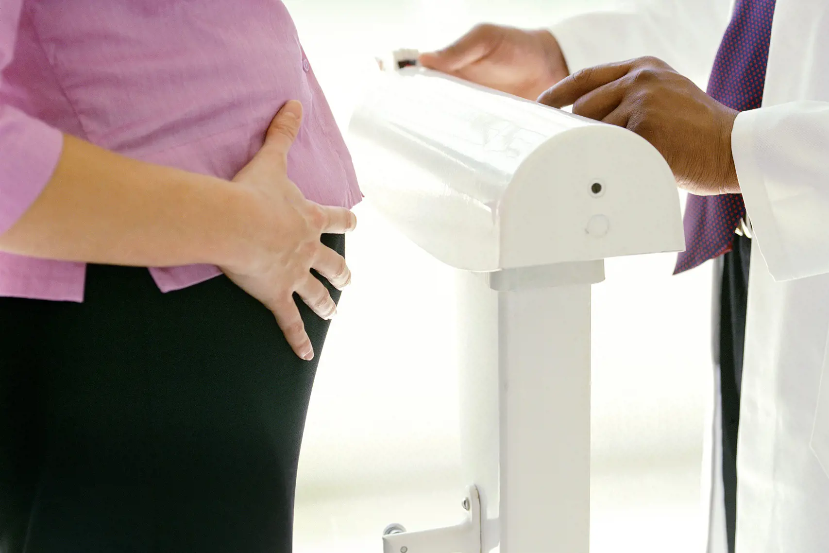 Gravid kvinne står på vekt