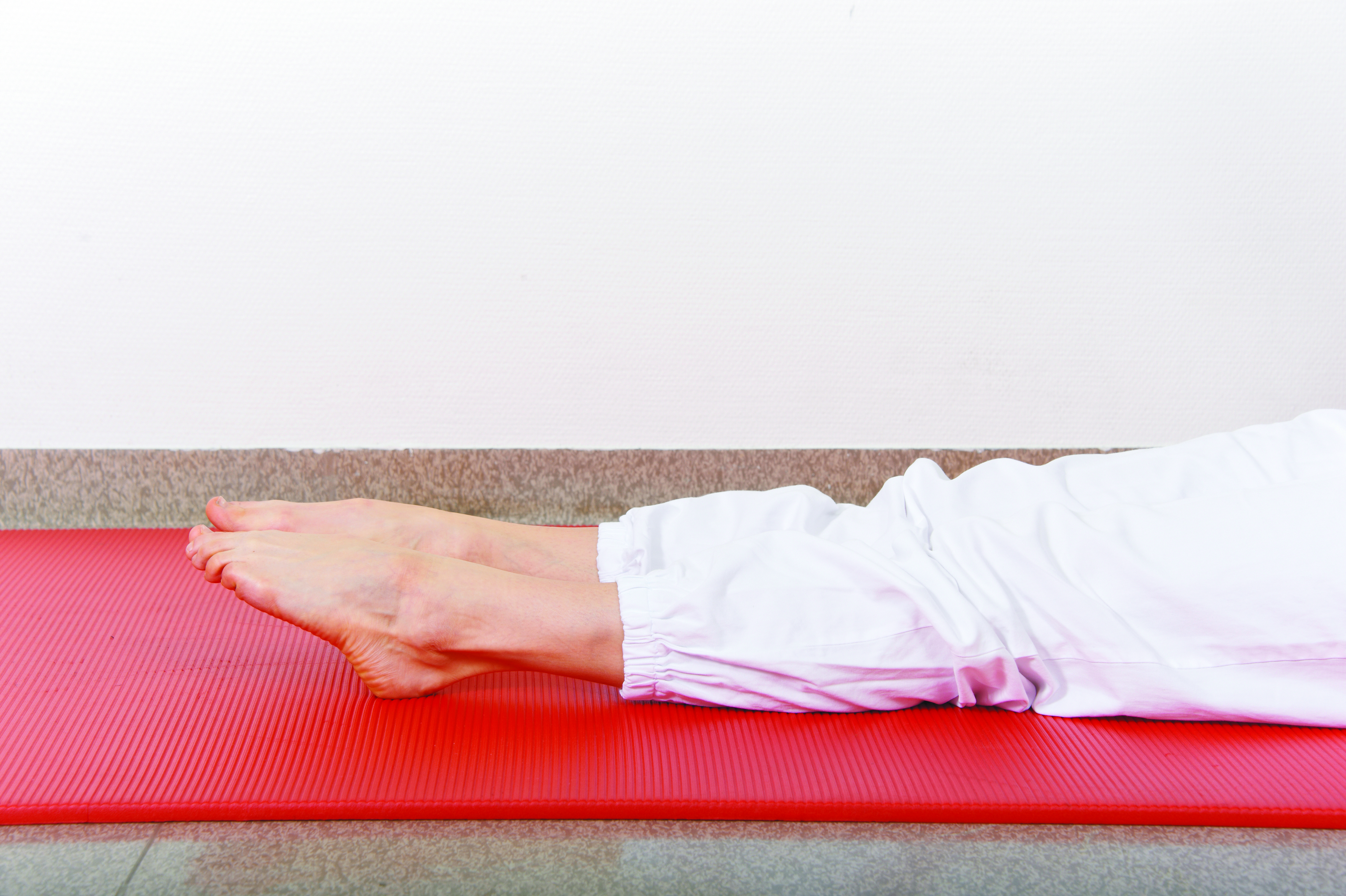 Bilde av løvelse: Ligg med strake ben. Bøy og strekk godt opp og ned i anklene.