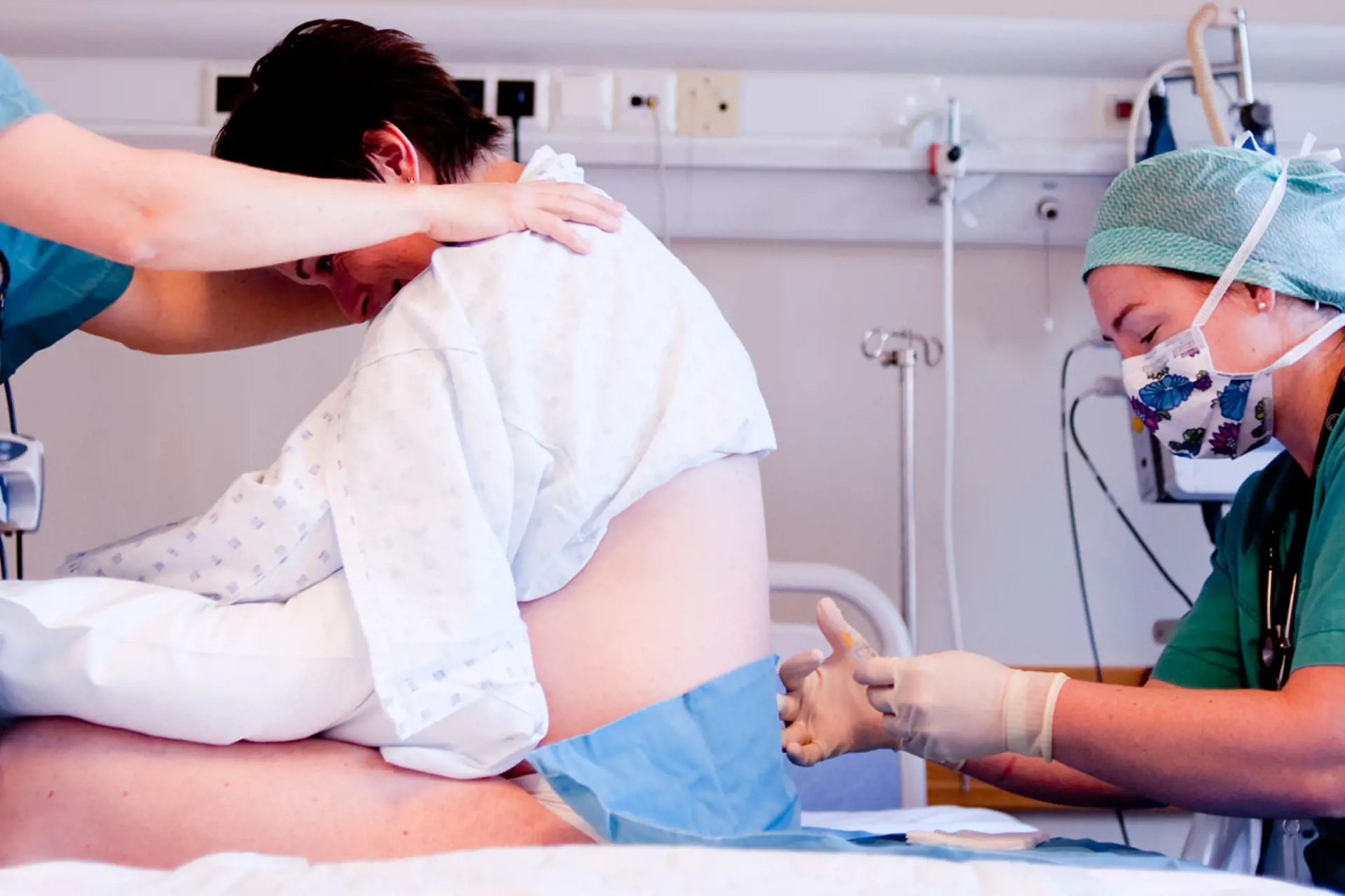 Helsepersonell setter epidural på gravid kvinne. Foto