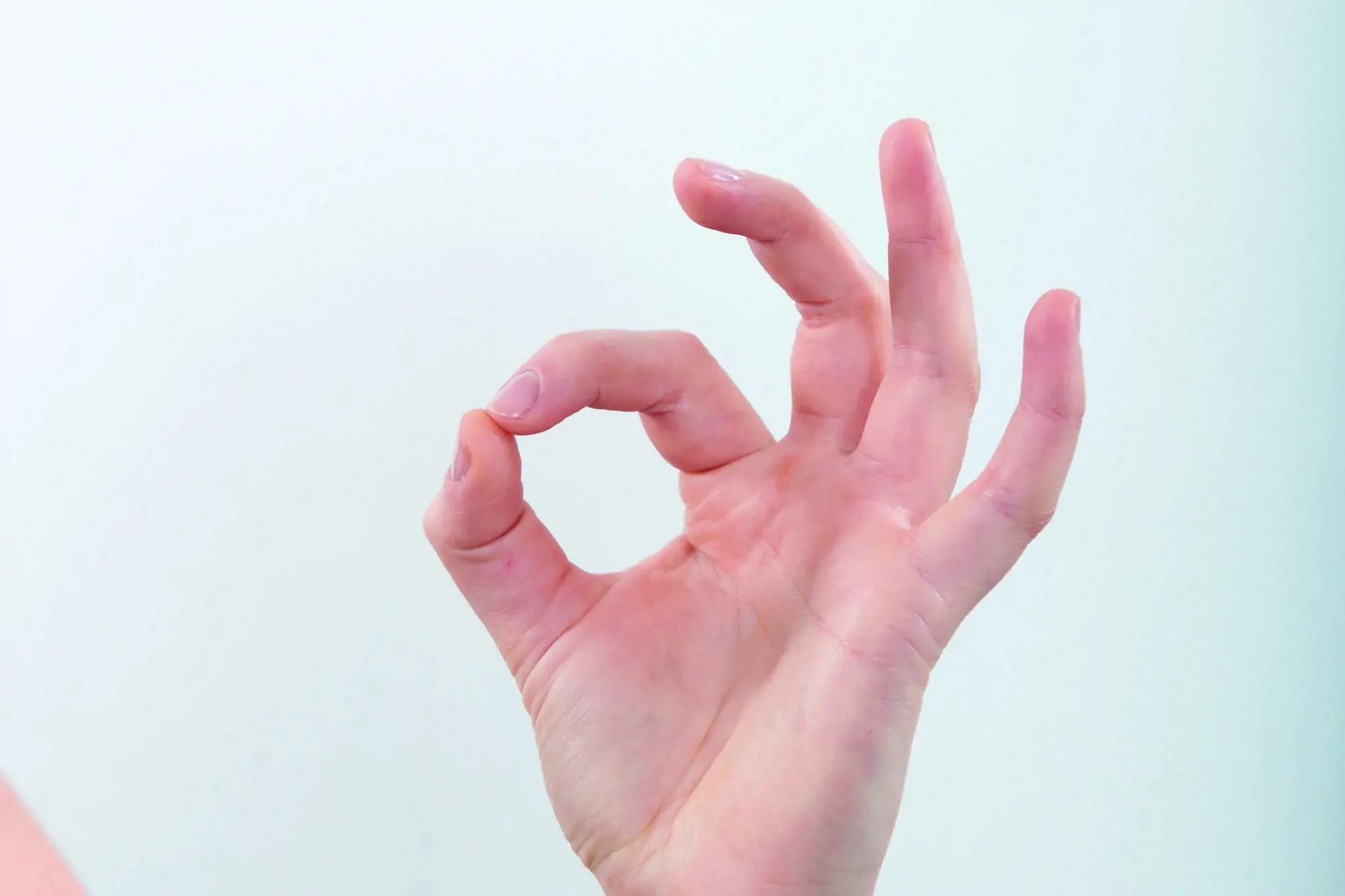 Bilde av en hånd hvor tommel og pekefinger er fingertupp mot fingertupp
