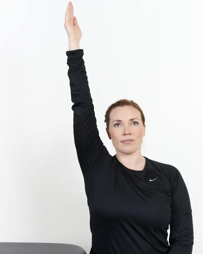 Dame som strekker den ene hånden opp mot taket