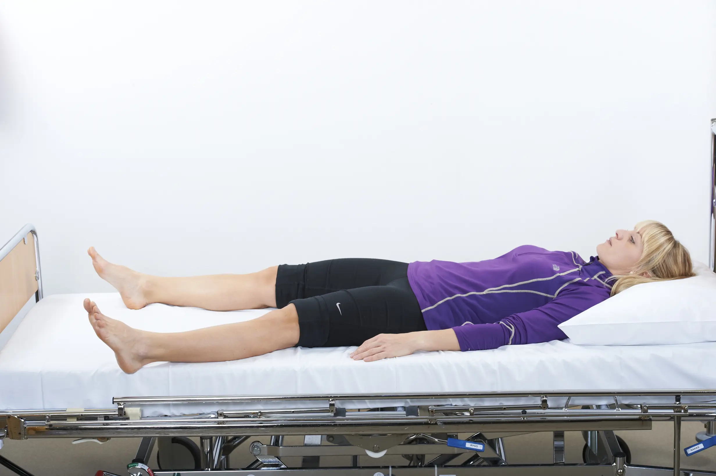 Person ligger på rygg, beina peker ut mot sidene.