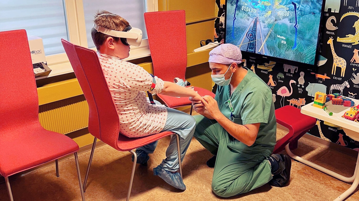 Sykepleier som legger inn kanyle mens barnet har på VR-briller
