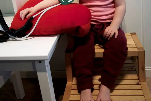 Jente med mansjett på armen for blodtrykksmåing.